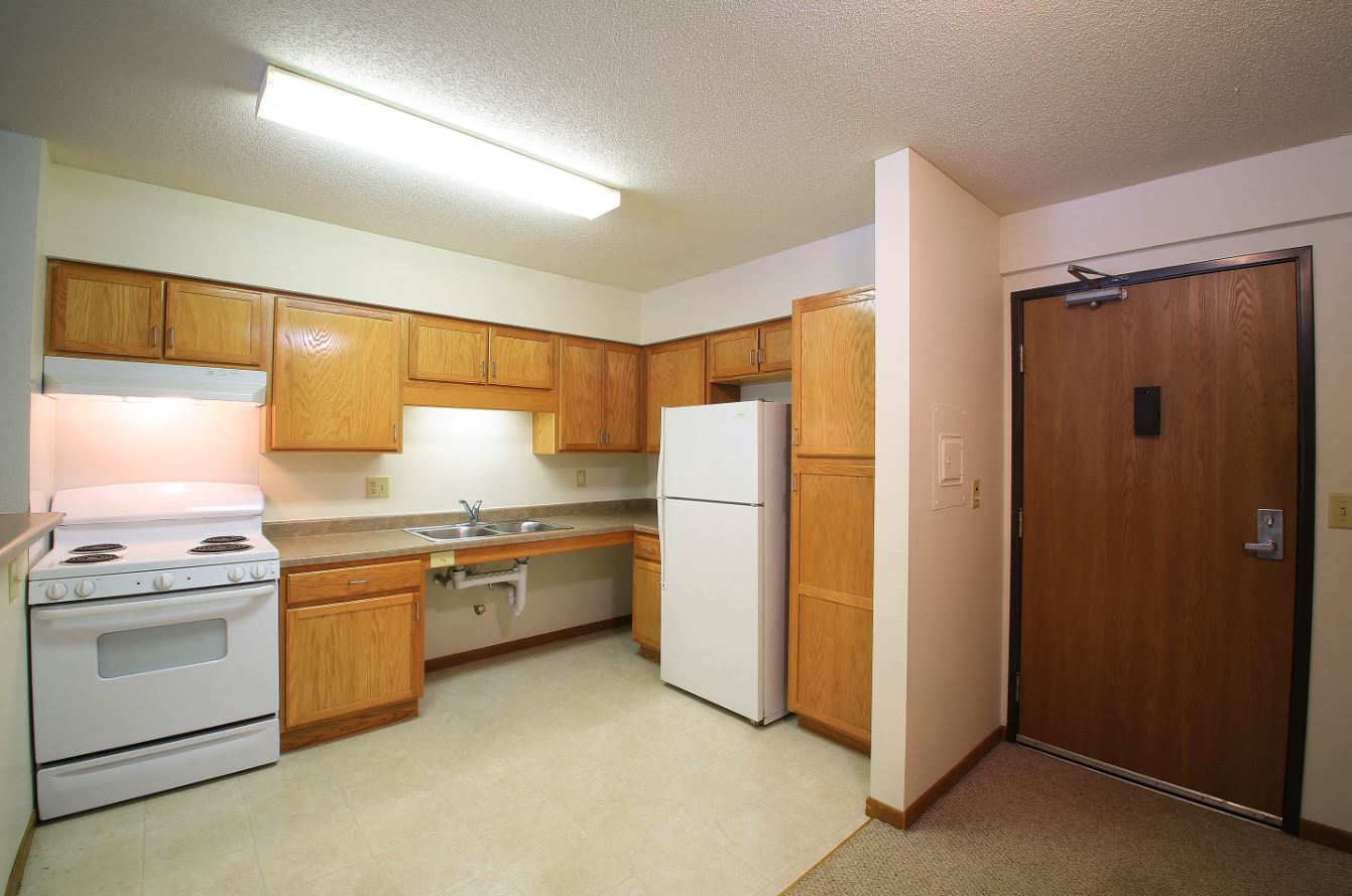 a kitchen with white appliances and wooden cabinets