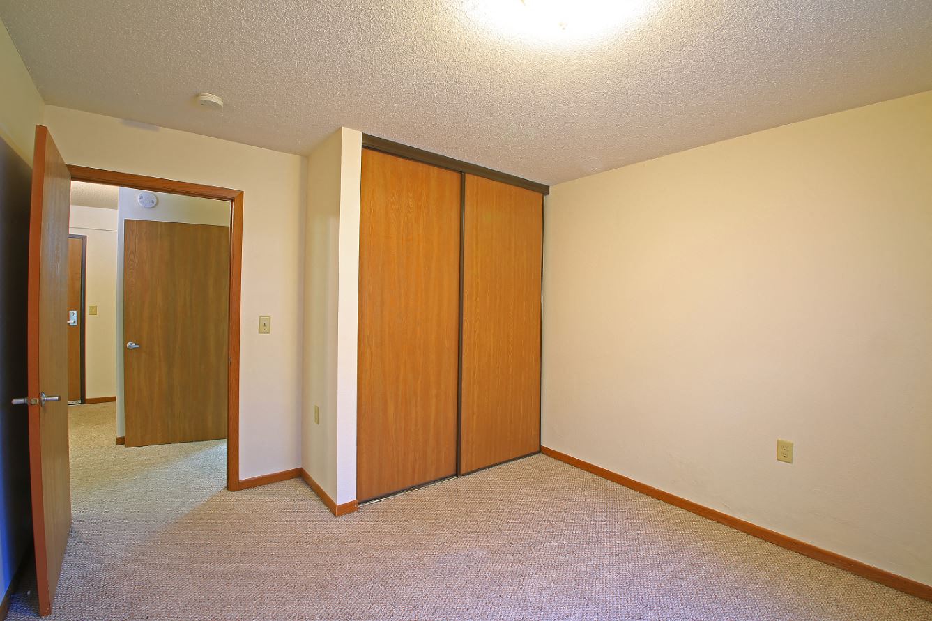 a bedroom with a closet and a door to a hallway