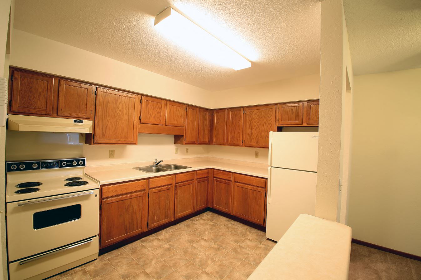 a kitchen with white appliances and wooden cabinets