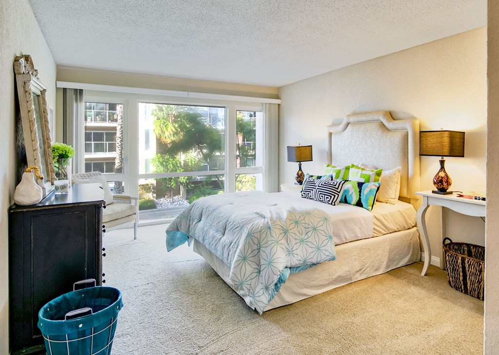 a bedroom with a bed and a large window