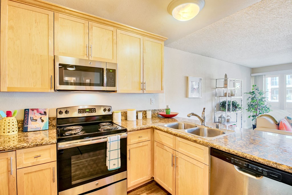 a kitchen with wooden cabinets and appliances and granite counter tops