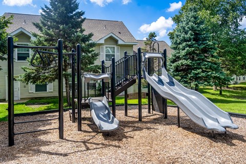 A playground with a slide, swings, and a climbing frame.