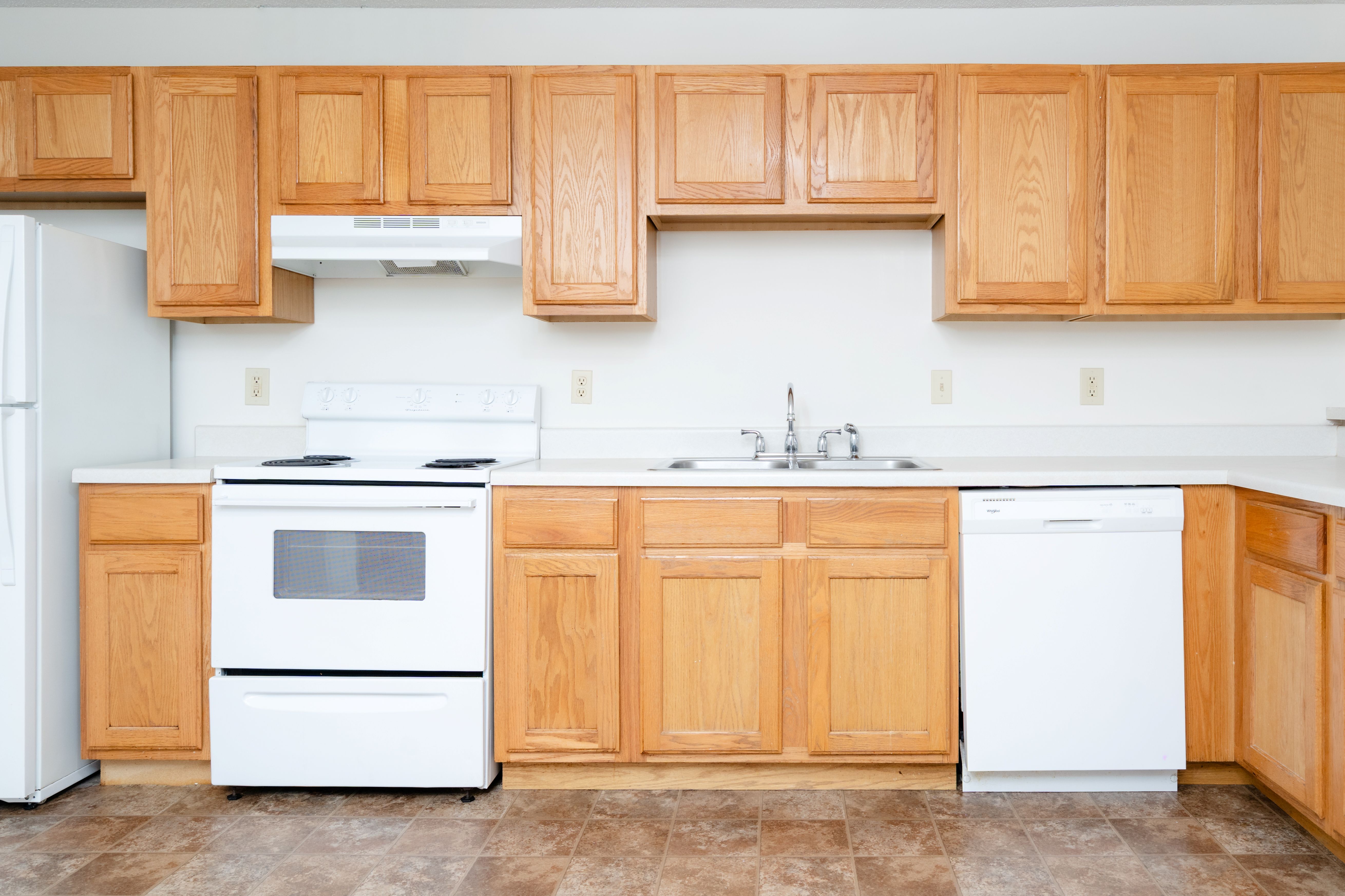 A kitchen with wooden cabinets and white appliances.