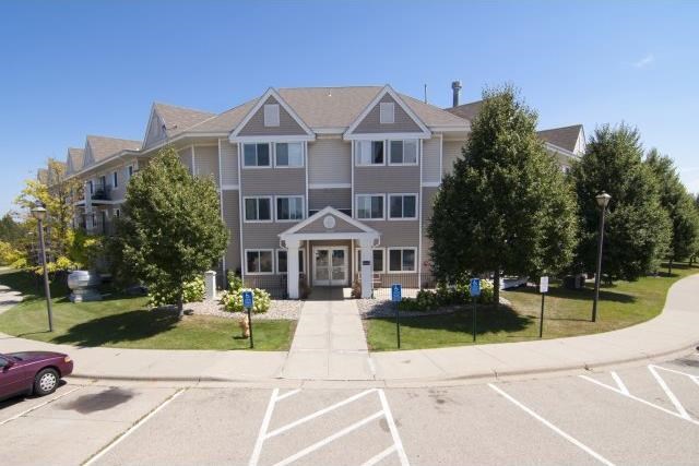 an empty parking lot in front of a large house