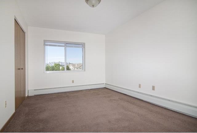 an empty room with a window and a carpet