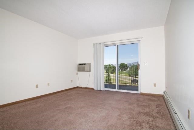 an empty living room with a door to a balcony