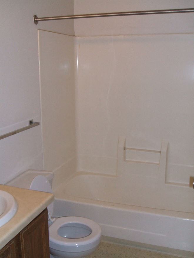 a bathroom with a toilet and a tub and a sink