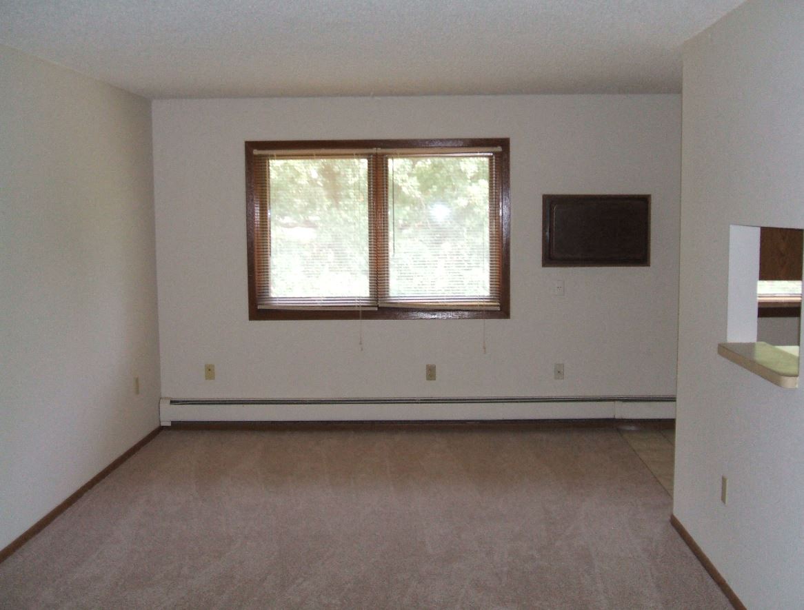 an empty living room with a window in it