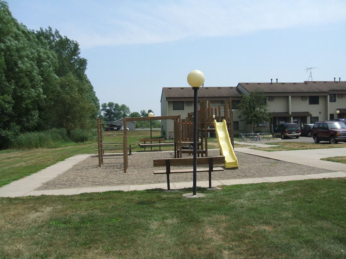 a playground in a park in front of a building