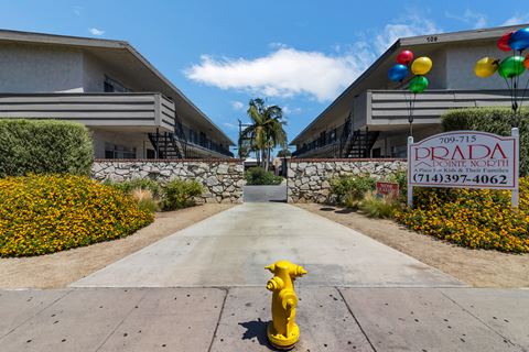 a yellow fire hydrant in front of a building with a sign on the sidewalk