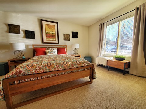 A bedroom with a large bed and a small bed in the corner.