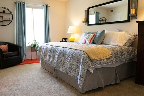 A bedroom with a large bed and a mirror above it.