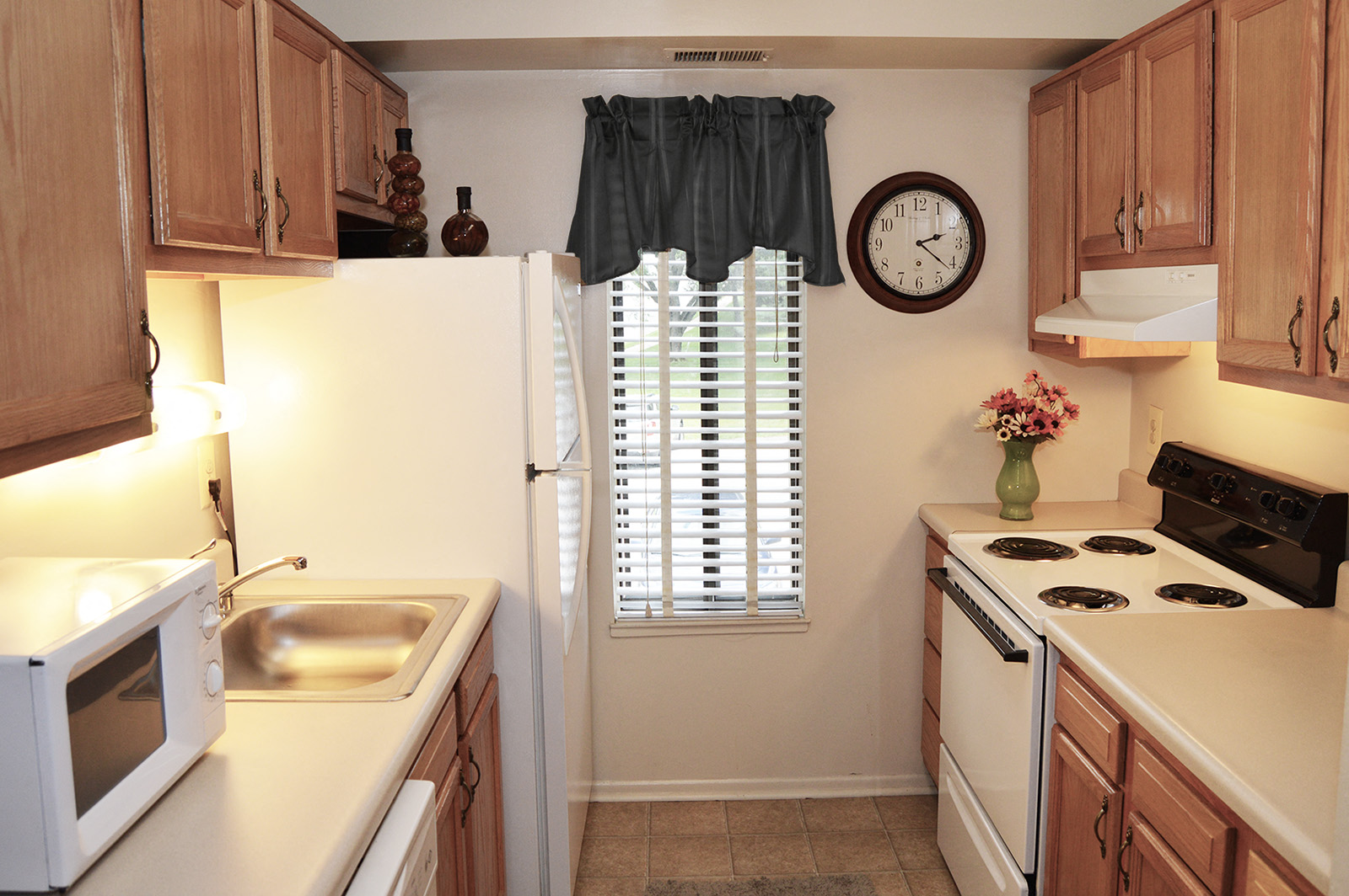 A kitchen with wooden cabinets and a white refrigerator.