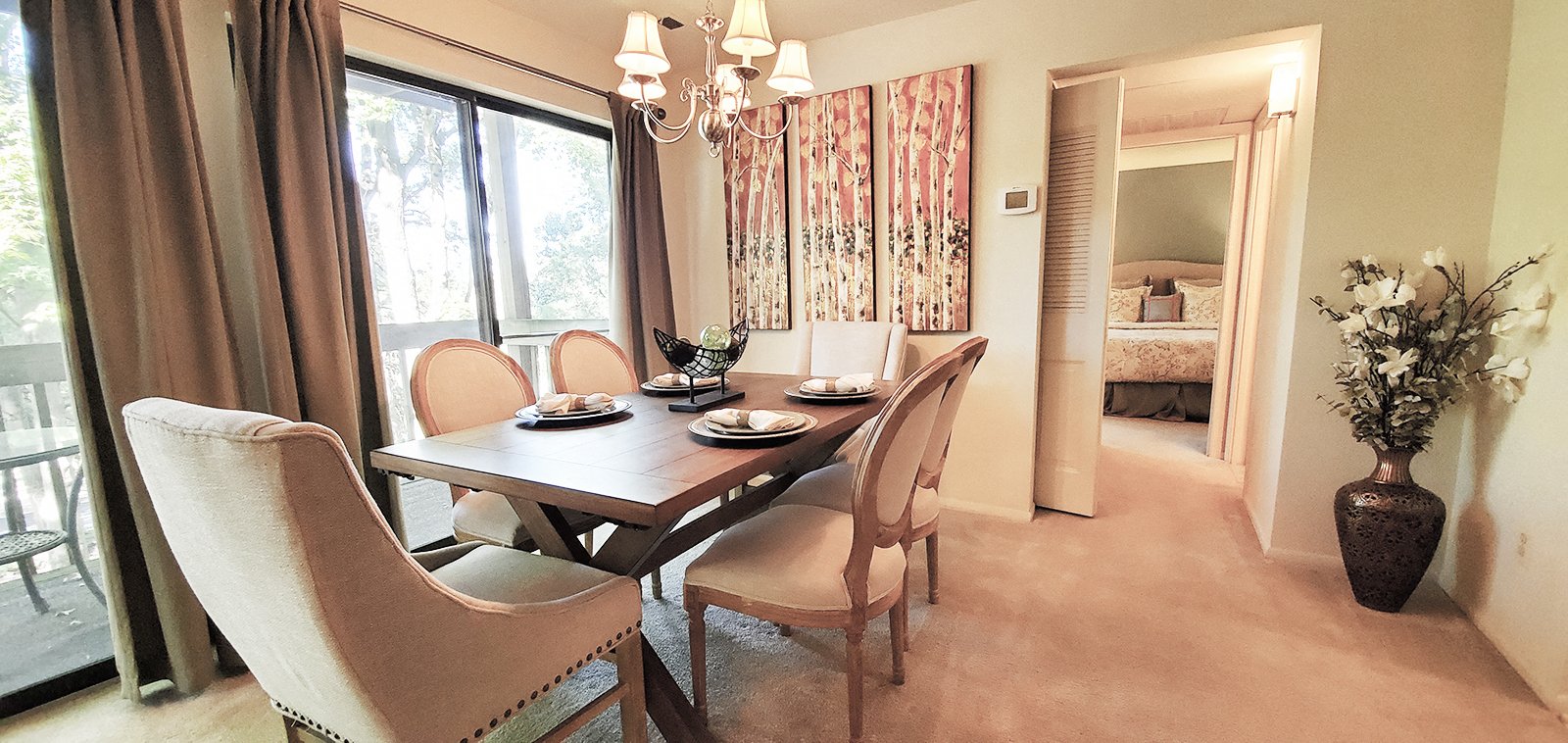 A dining room with a table set for four.