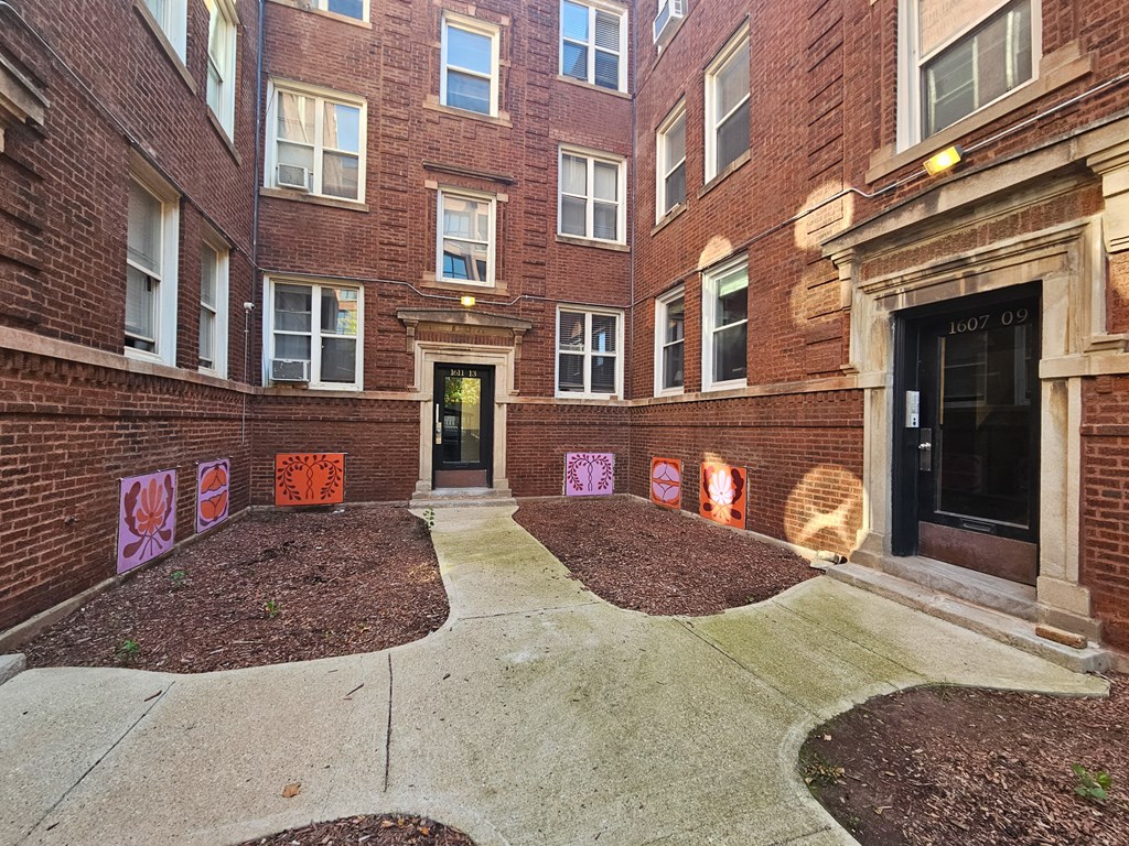 the entrance to a brick building with graffiti on the sidewalk
