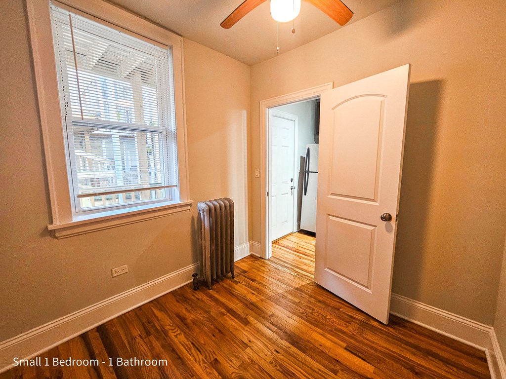a bedroom with a radiator and a door to a bathroom