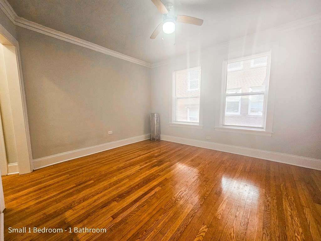 the living room of an empty house with wood floors and a ceiling fan