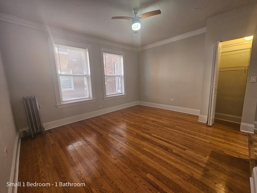 the living room of a house with wooden floors and a ceiling fan