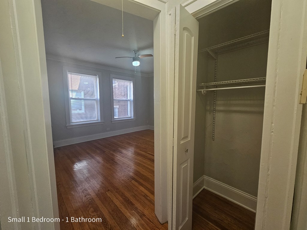 a bedroom with a closet and a window and a hard wood floor
