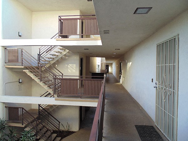 a view of a hallway with stairs and a door