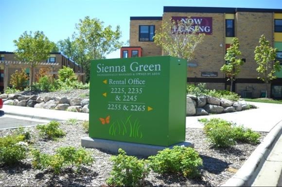 a green sign in front of a building