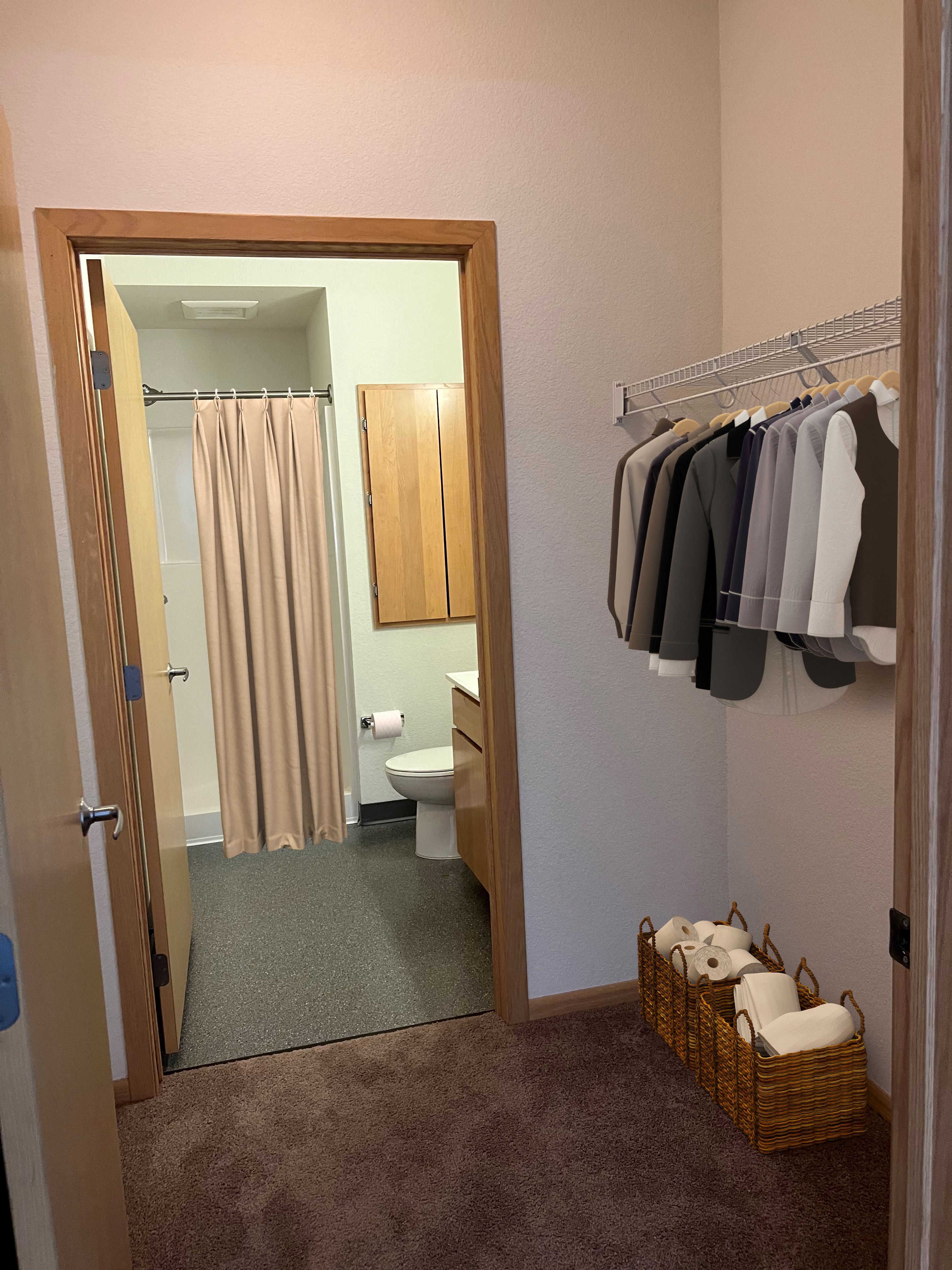 a bathroom with a shower and a closet with clothes in it