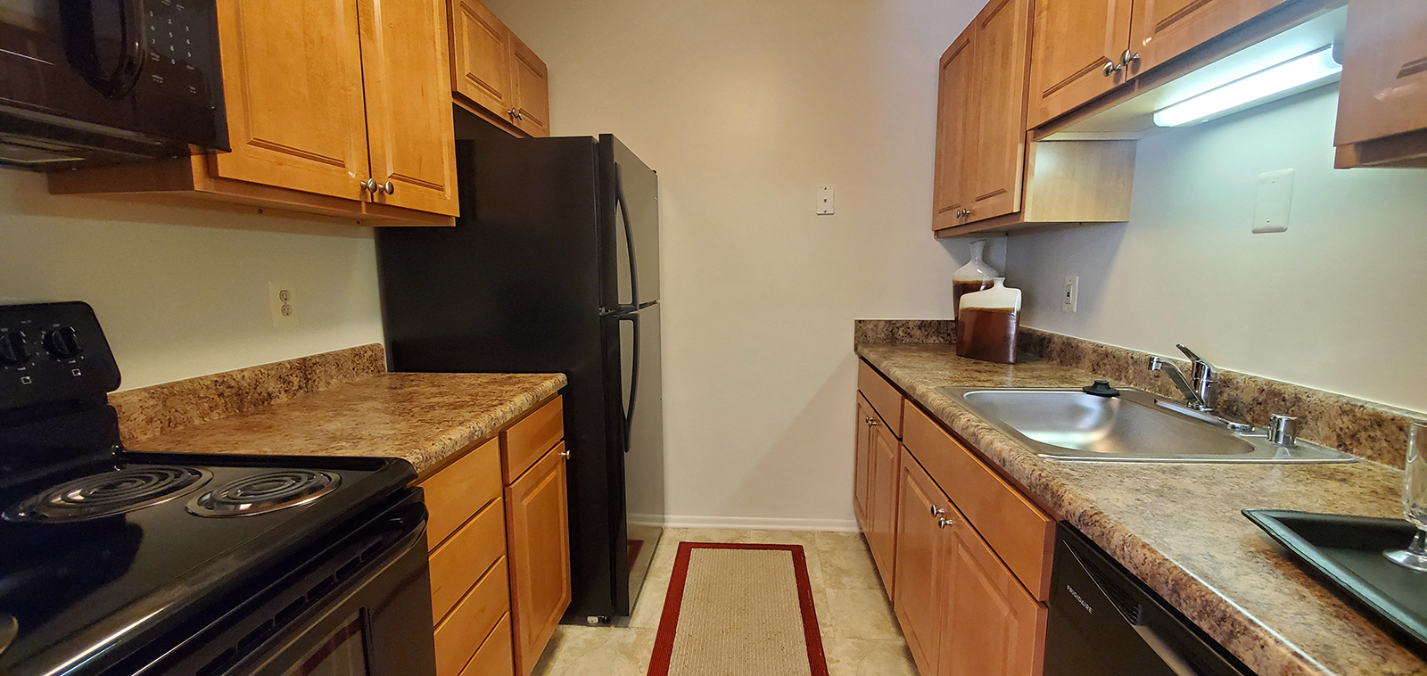 a kitchen with granite counter tops and a black refrigerator