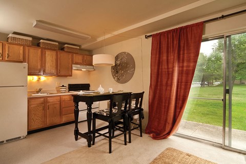 A kitchen with a table and chairs and a refrigerator.