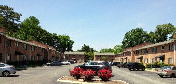 a city street with cars parked in front of apartment buildings
