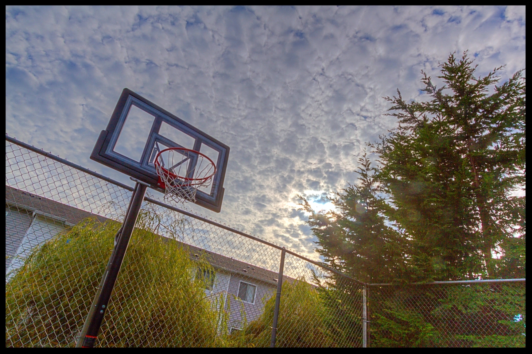 a basketball hoop in front of a fence