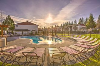 Glistening Swimming Pool at Sunset with lounge chairs and Meticulous Landscaping at Pinewood Square Apartment Homes, Lynnwood, WA
