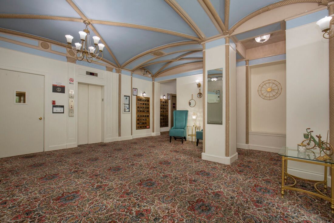Lobby View of Pattered Carpeting, Blue Painted Ceiling with Detailed Gold Accent Pieces, and Large Chandeliers at Stockbridge Apartment Homes, Seattle