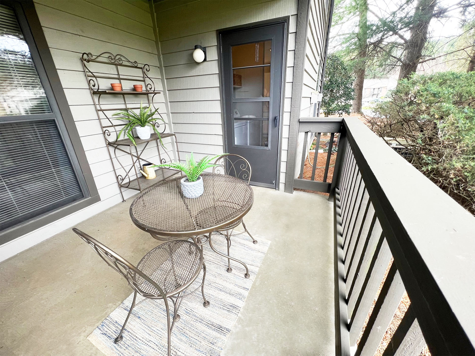 a small porch with a table and chairs and a door