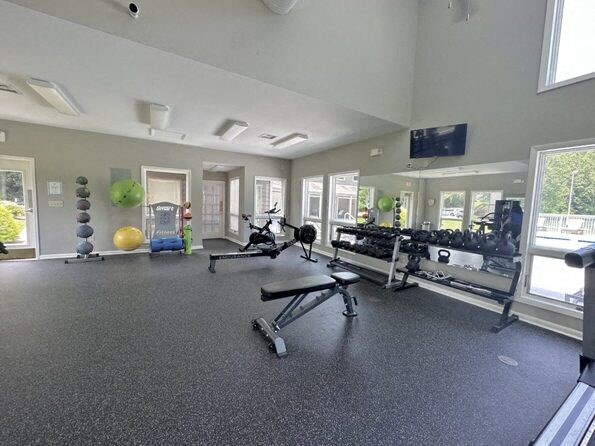 a gym with weights and other equipment on the floor and windows