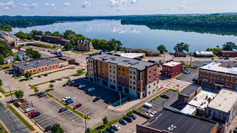 an aerial view of a building with a lake in the background