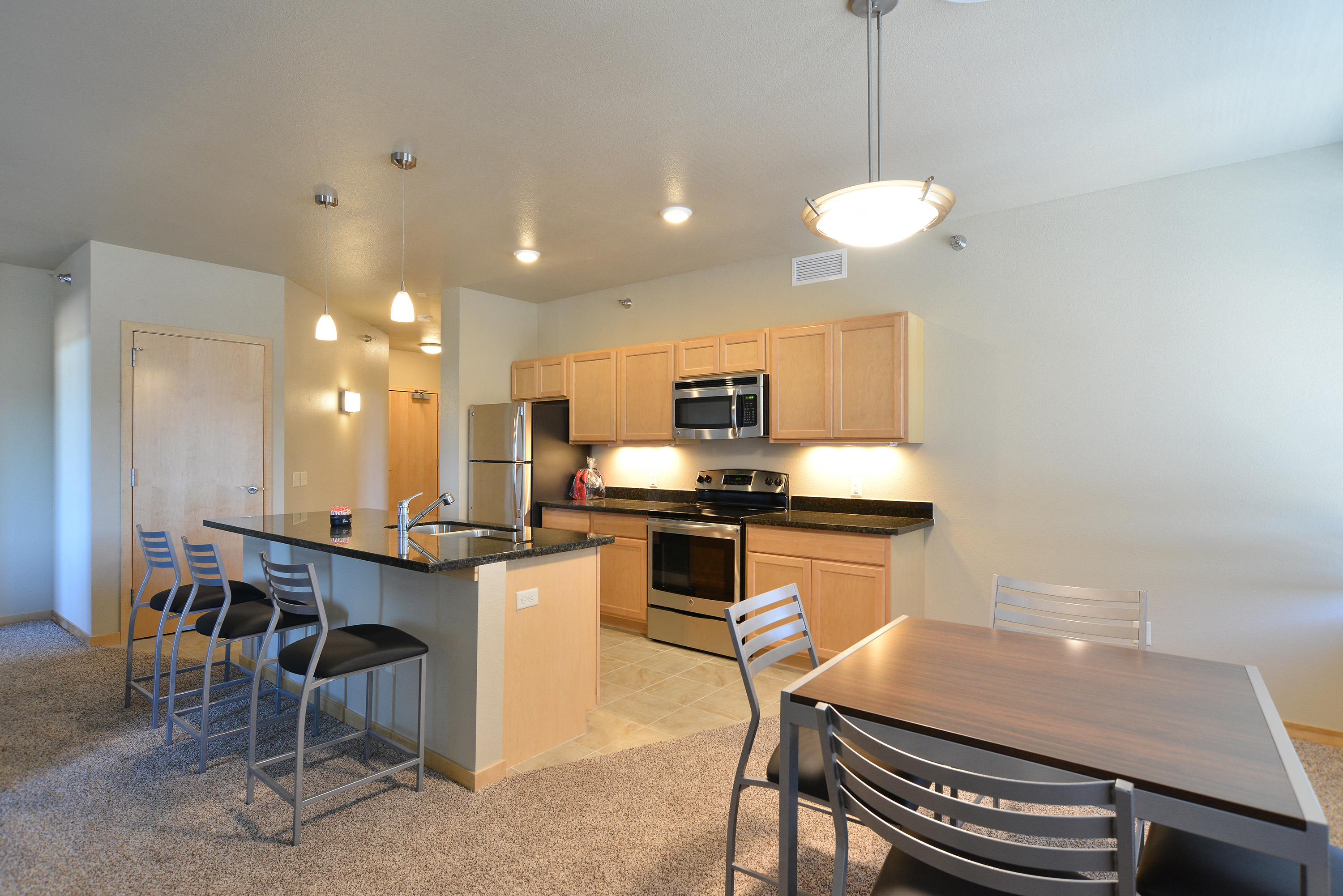 a kitchen and dining area with a wooden table and chairs