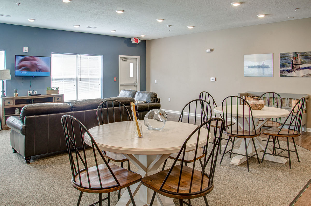 a dining room table with chairs and a living room with a couch