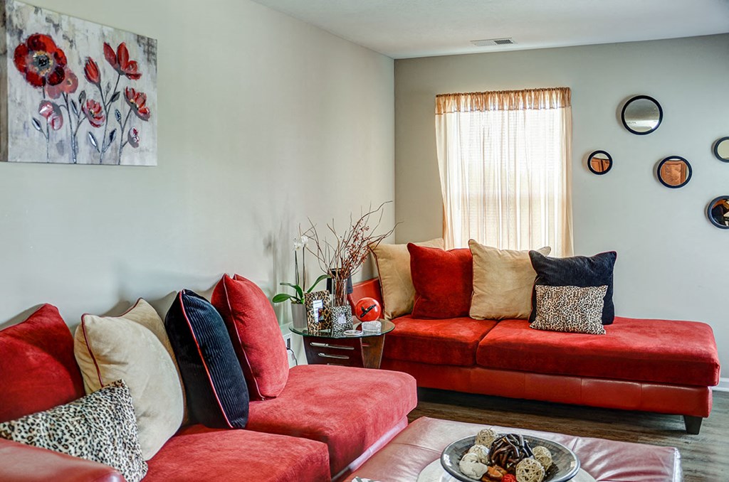 a living room with red couches and a table