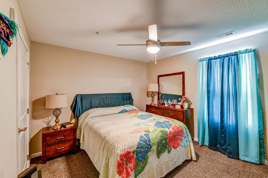 a bedroom with a bed and a ceiling fan