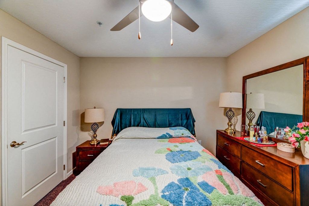a bedroom with a bed and a ceiling fan