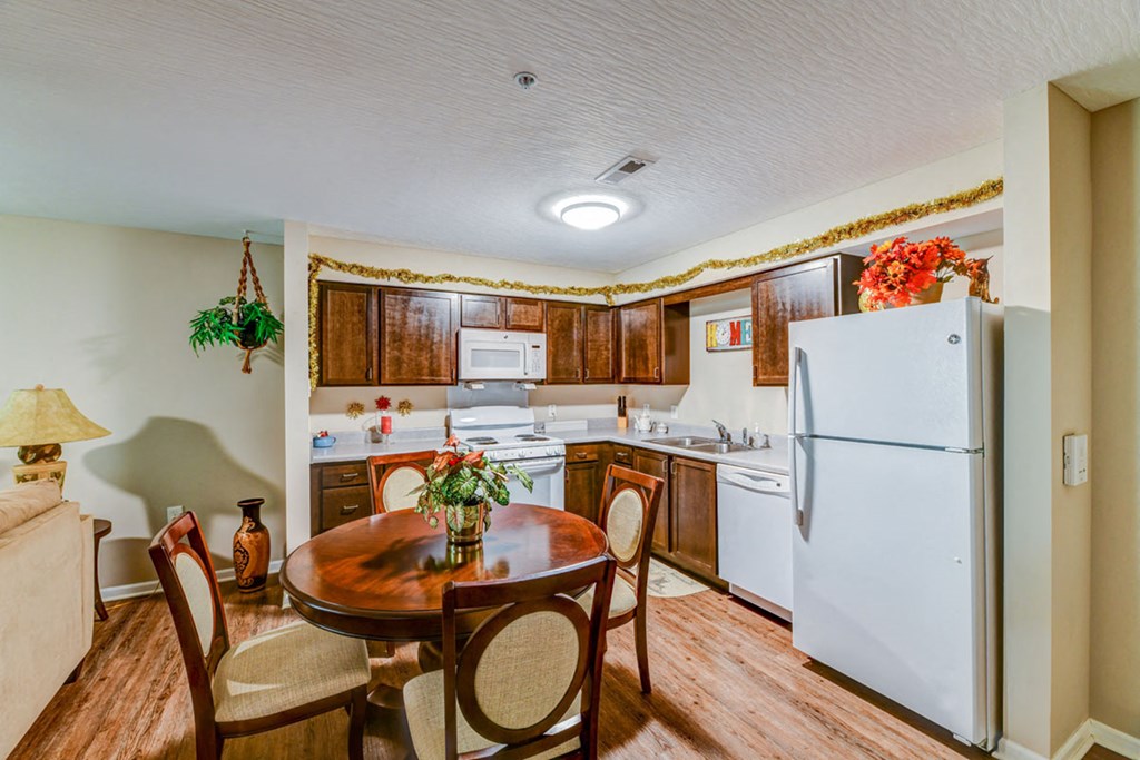 a kitchen with white appliances and a dining room table