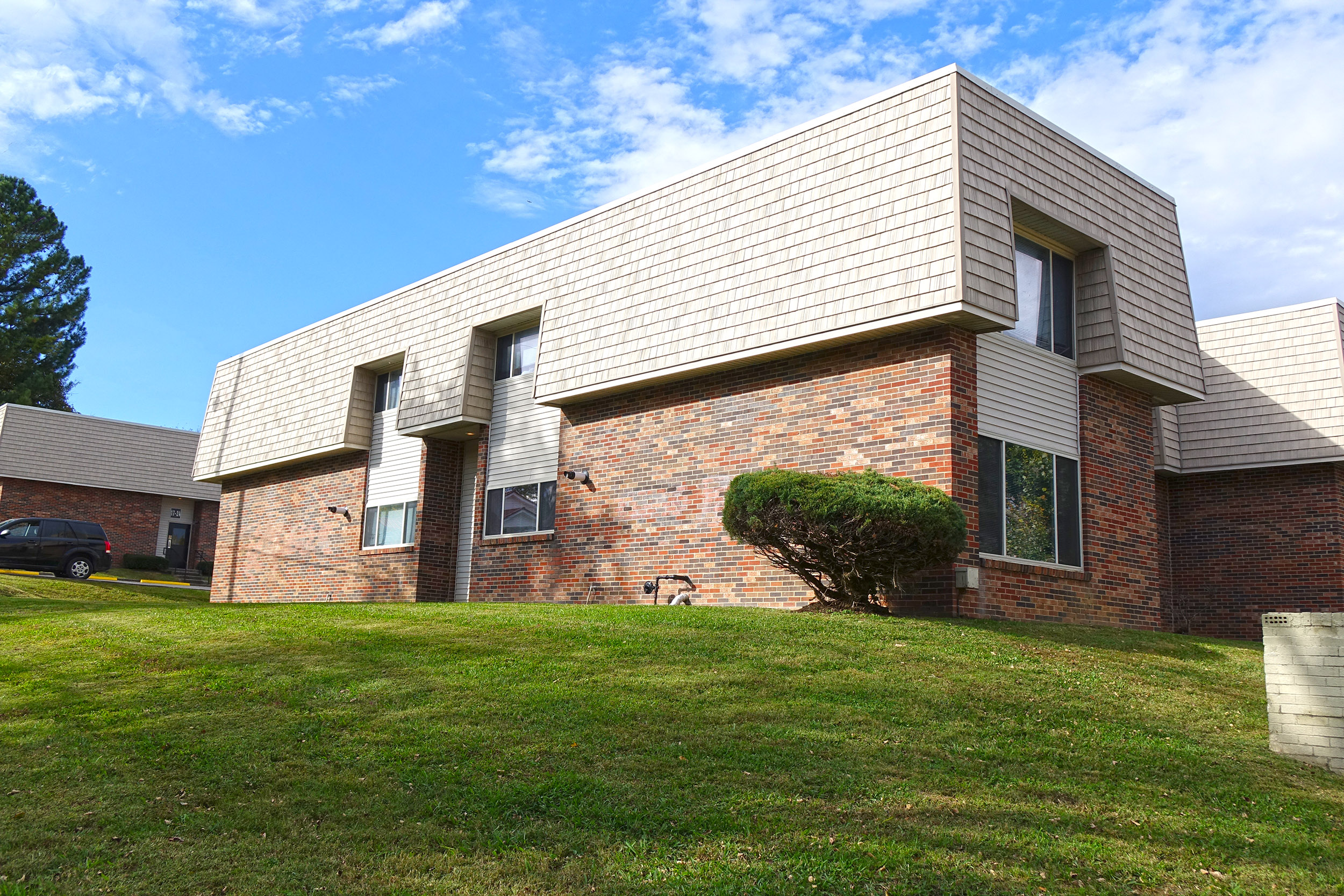 a view of the side of a brick building with white siding