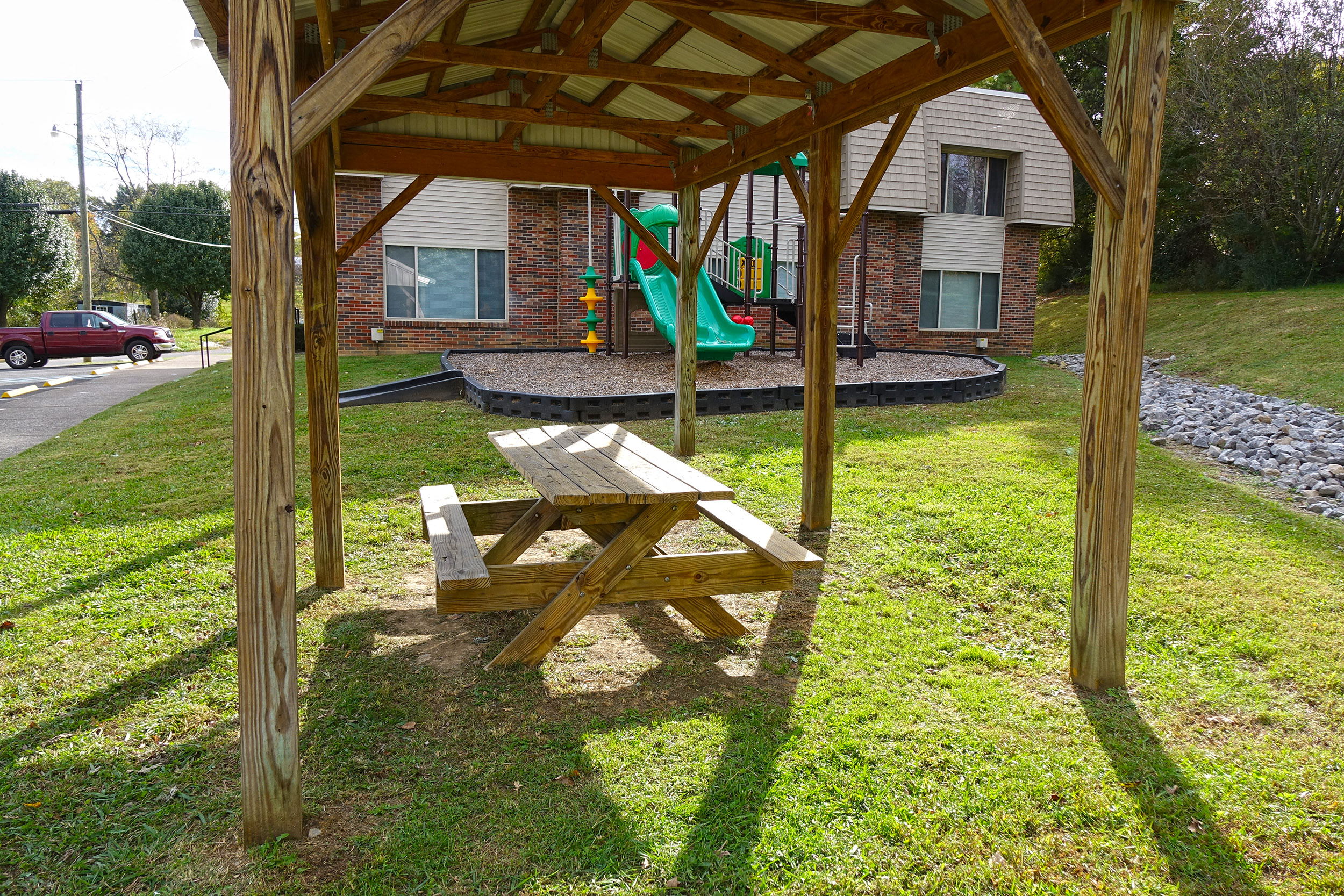 a picnic table in a park with a playground