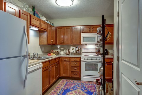 a kitchen with white appliances and wooden cabinets