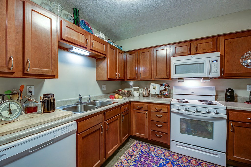 a kitchen with white appliances and wooden cabinets