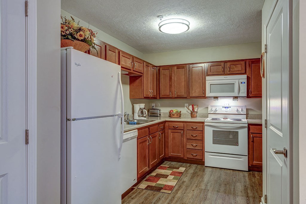 a kitchen with white appliances and wooden cabinets