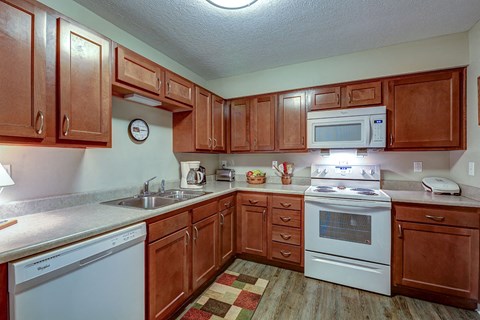 a kitchen with white appliances and wooden cabinets