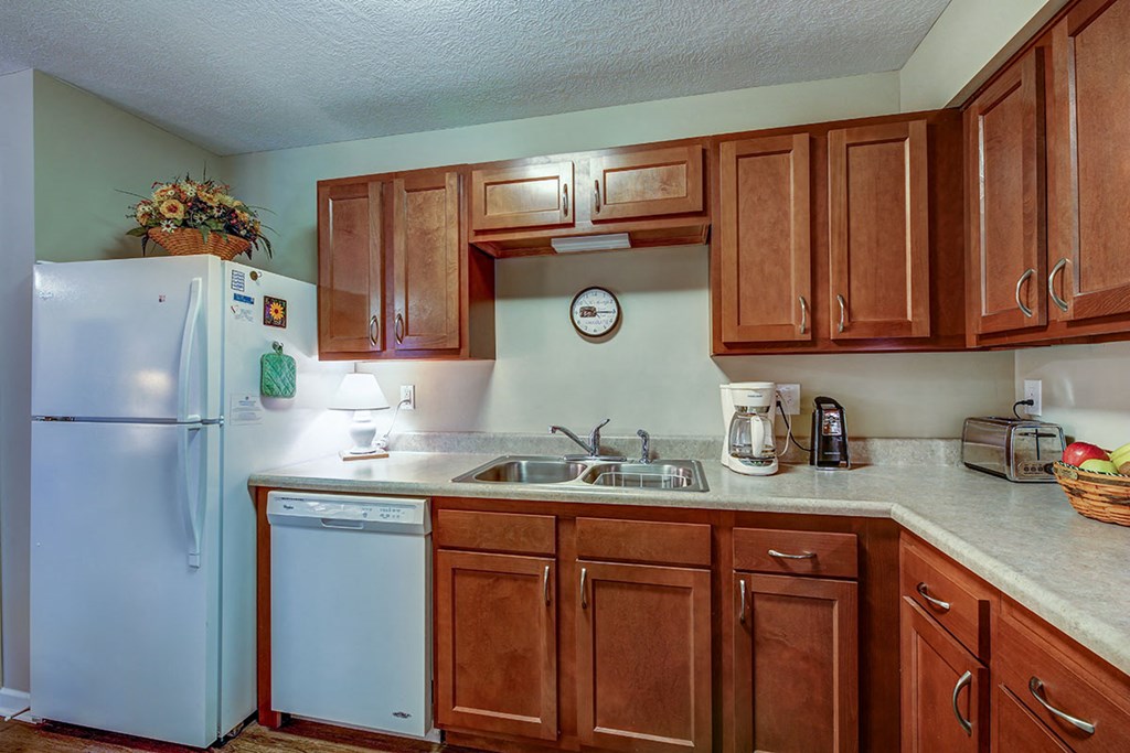 a kitchen with white appliances and wooden cabinets
