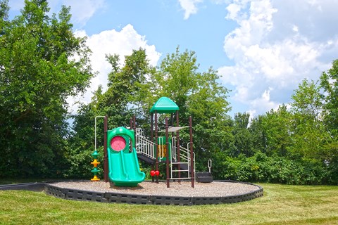 a playground with a swing set and a slide in a park