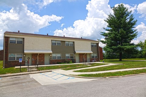 an apartment building with a sidewalk in front of it